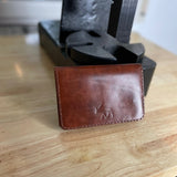 Reisepasshülle aus braun-rötlichem Leder, handgenäht für einen Reisepass, Scheckkarten oder Geldscheine, mit Logo Elch.