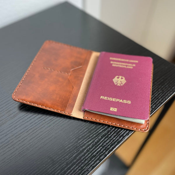 Reisepasshülle aus braun-rötlichem Leder, handgenäht für einen Reisepass, Scheckkarten oder Geldscheine, mit Logo Elch.