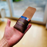 vertikaler Kartenhalter in der Farbe braun, handgenäht mit Logo Lakes&Woods leather goods in der Farbe Gold mit Lasche.